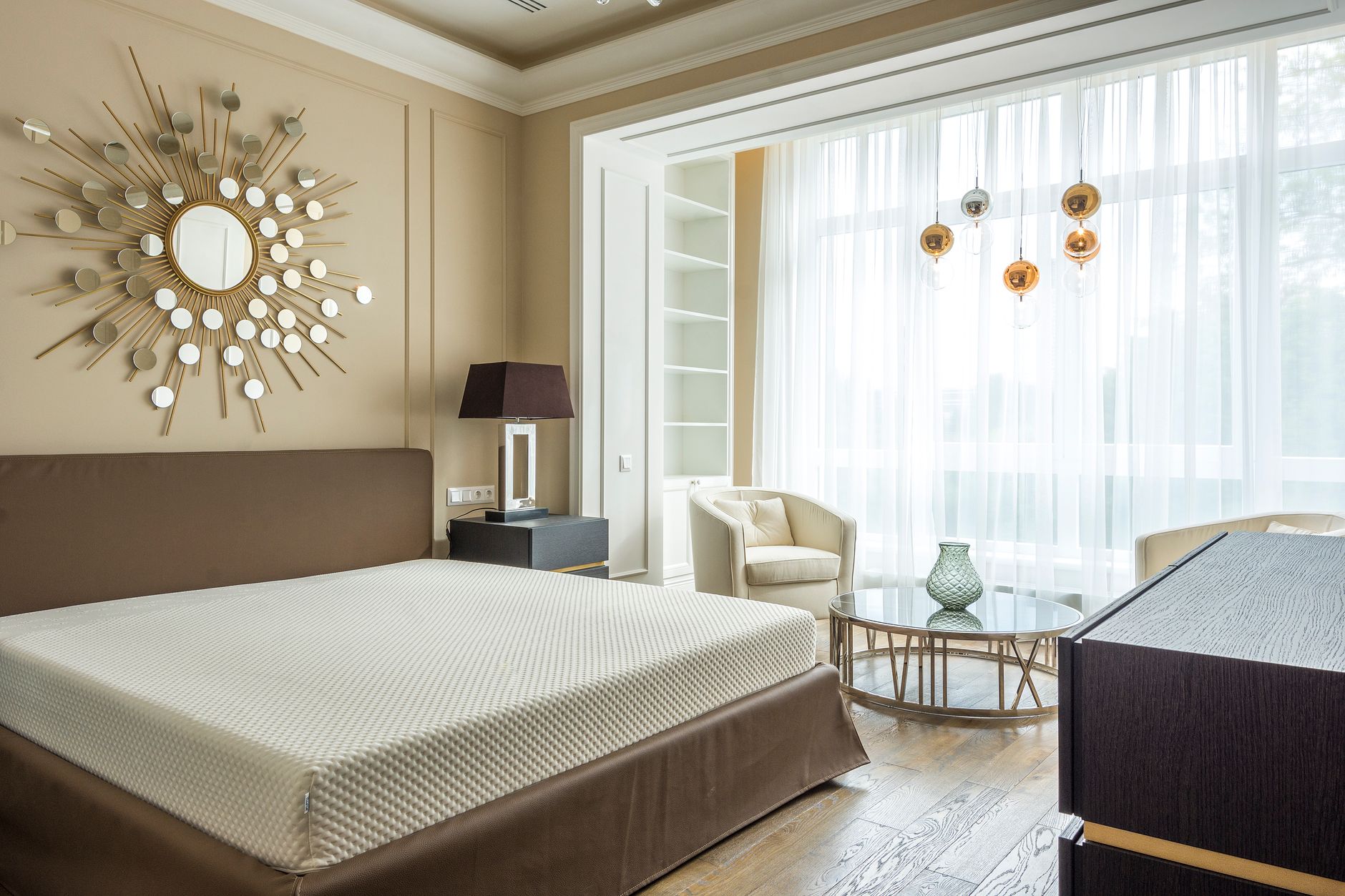 A calm, tidy bedroom with a wide window and light curtains; knowing how to reduce pollen in your home starts with keeping bedroom windows shut on high days.